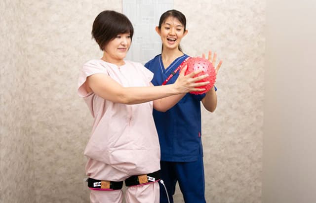 加圧トレーニングを受けている女性とスタッフ